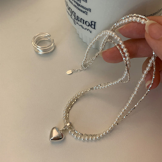Superposez de petits morceaux de colliers en forme de cœur en métal argenté
